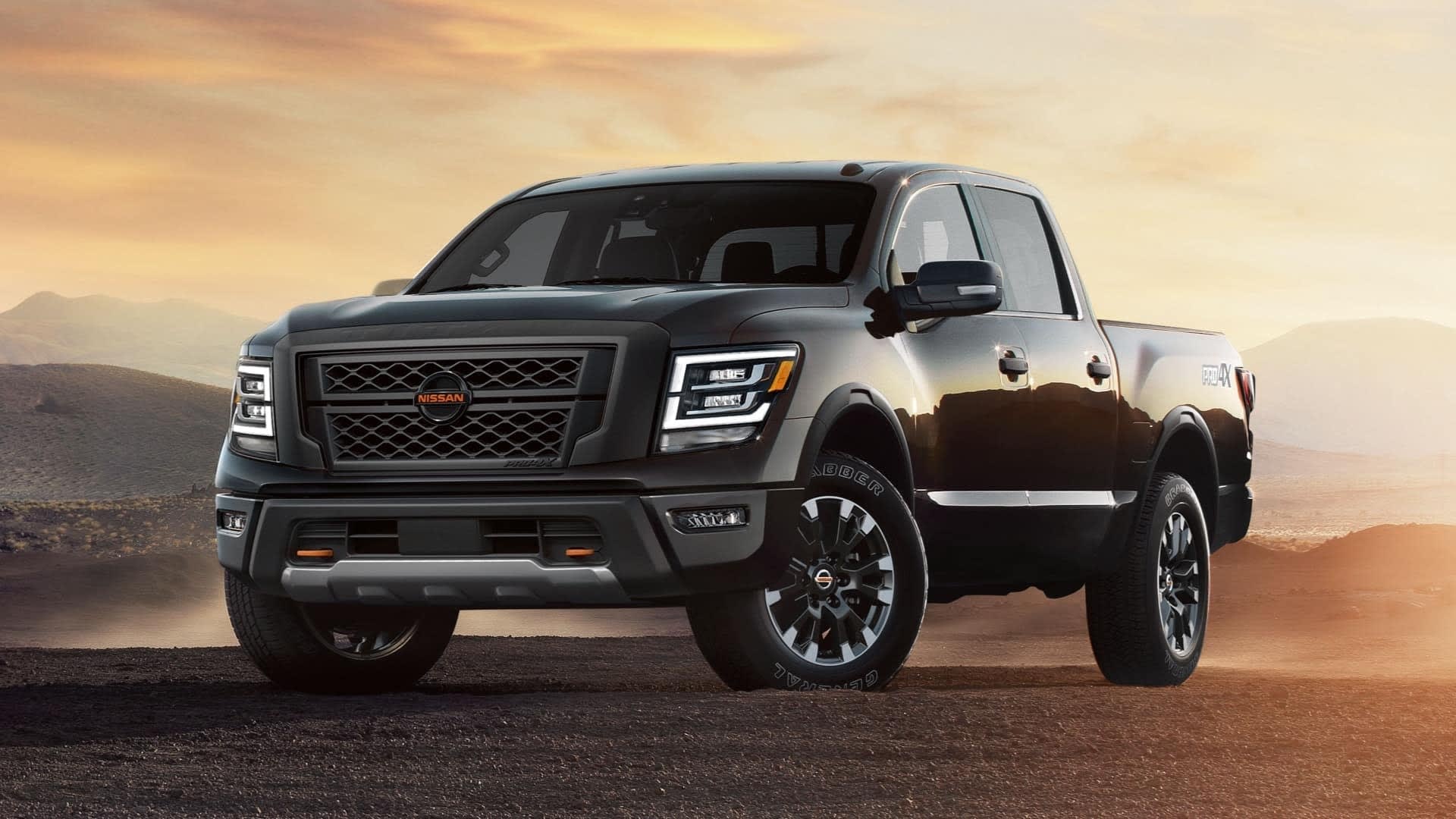 Black 2022 Nissan Titan parked on dirt at sunset.