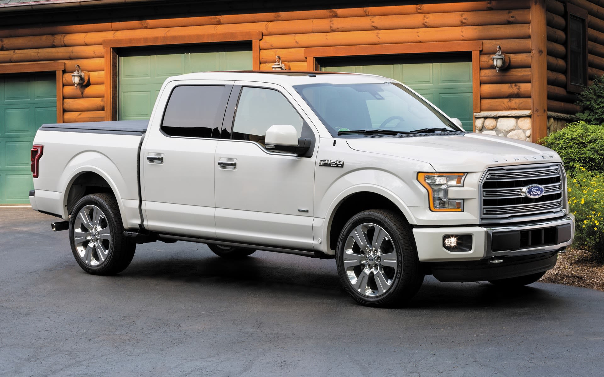 White 2016 model year Ford F-150, Supercrew in front of a log garage.