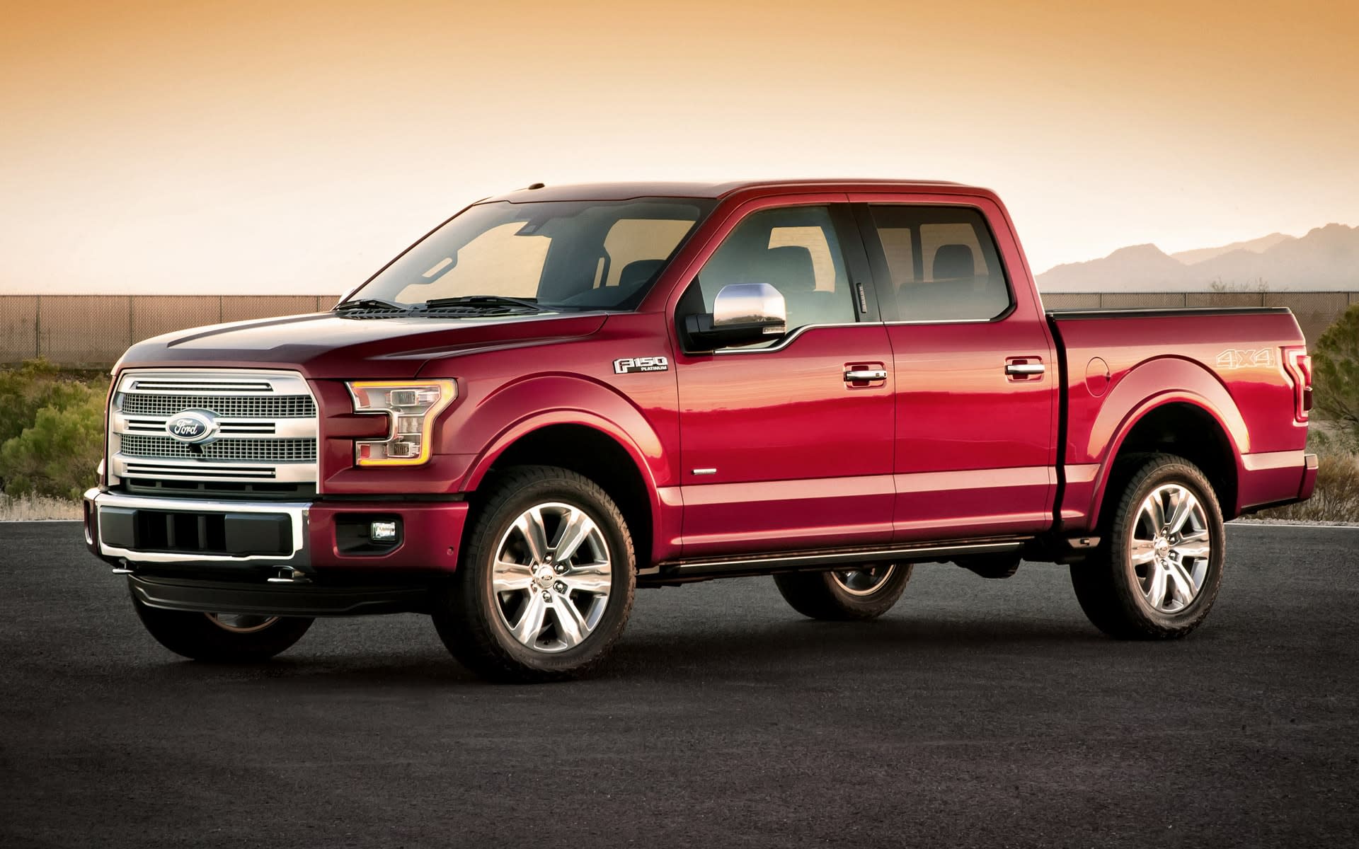 Red Ford F-150 at sunset parked on a country road.