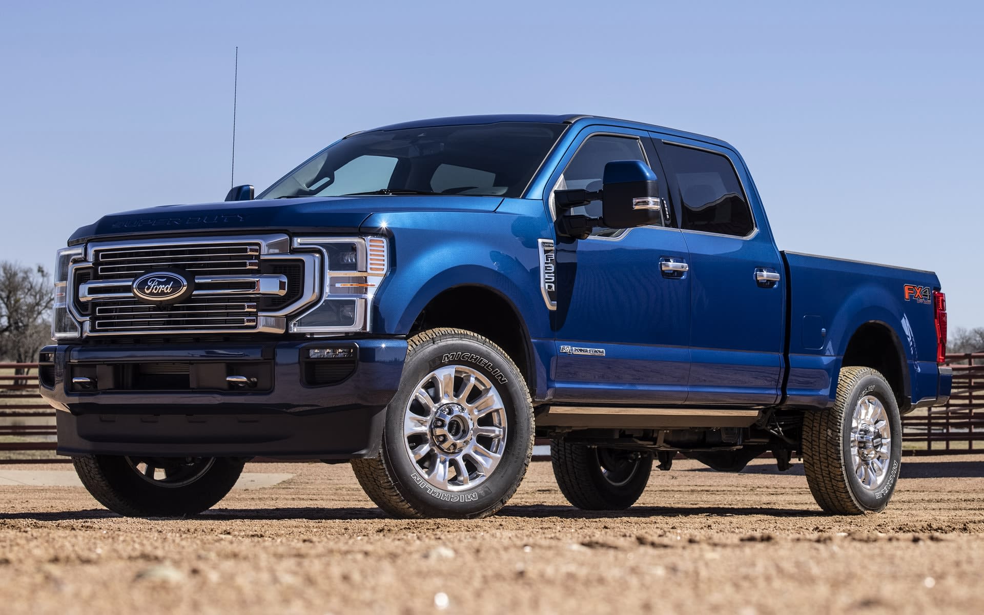 Blue Ford Super Duty F-350 with diesel engine parked on gravel.