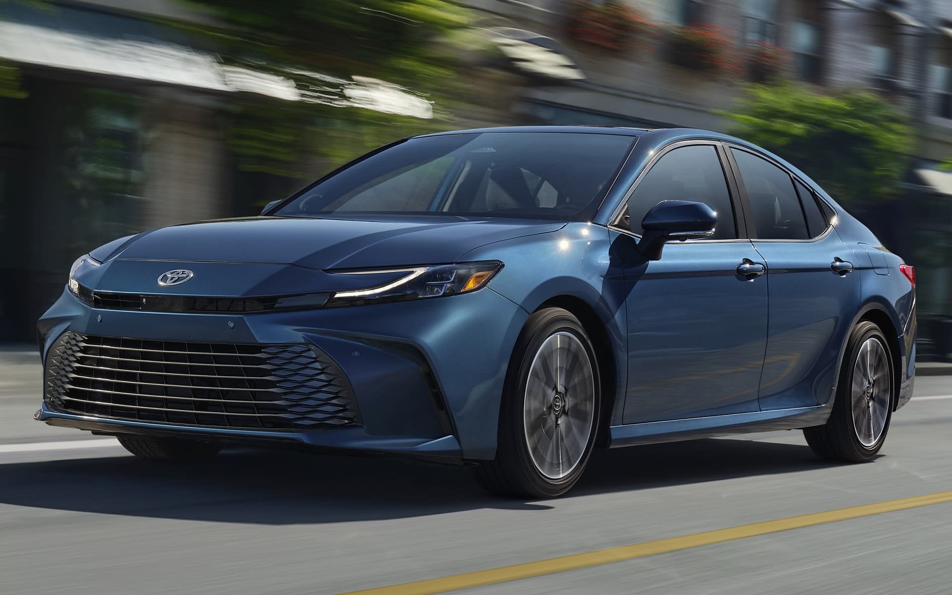 2025 Toyota Camry driving in the sunshine.