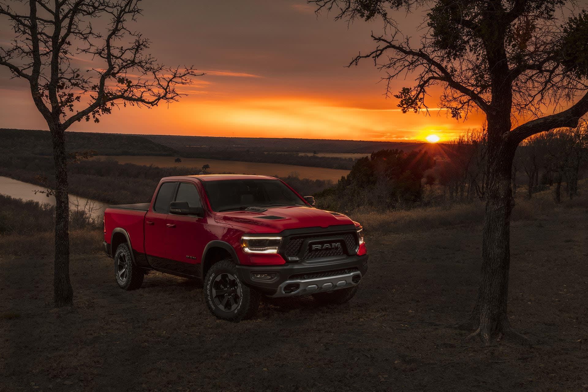 2019 Ram 1500 in red color, in a field during sunset.