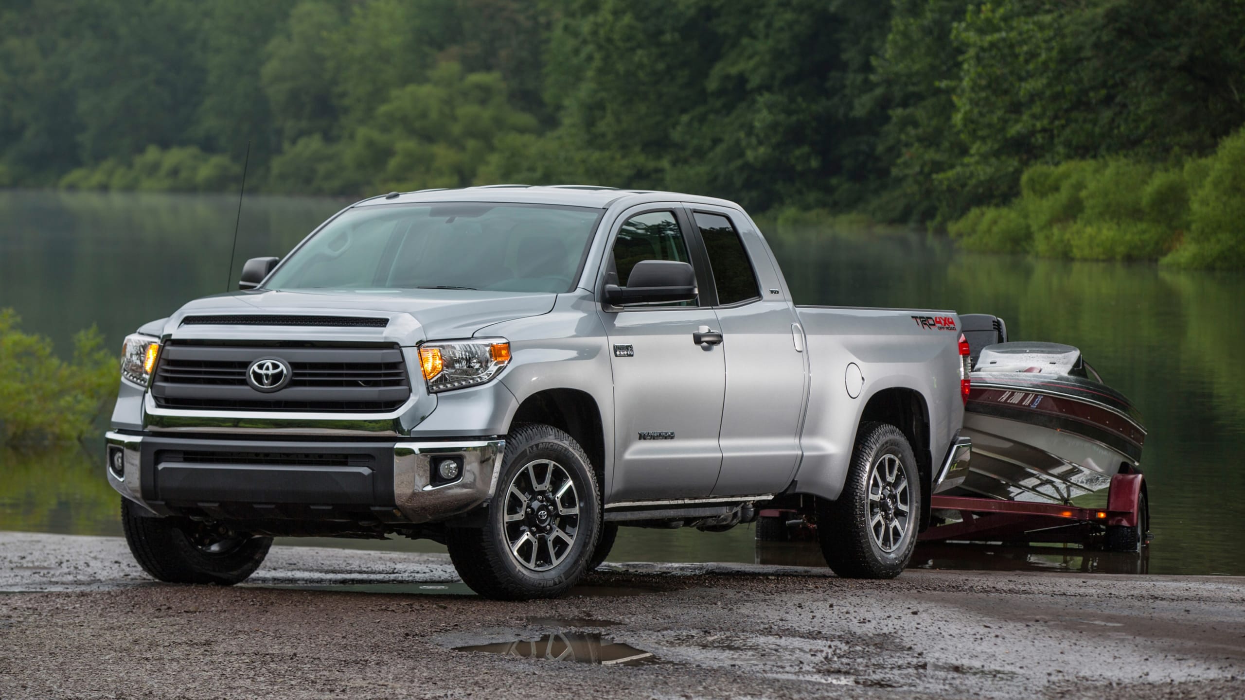 Silver Toyota Tundra with diesel engine demonstrating towing power by towing a heavy load out of a lake.