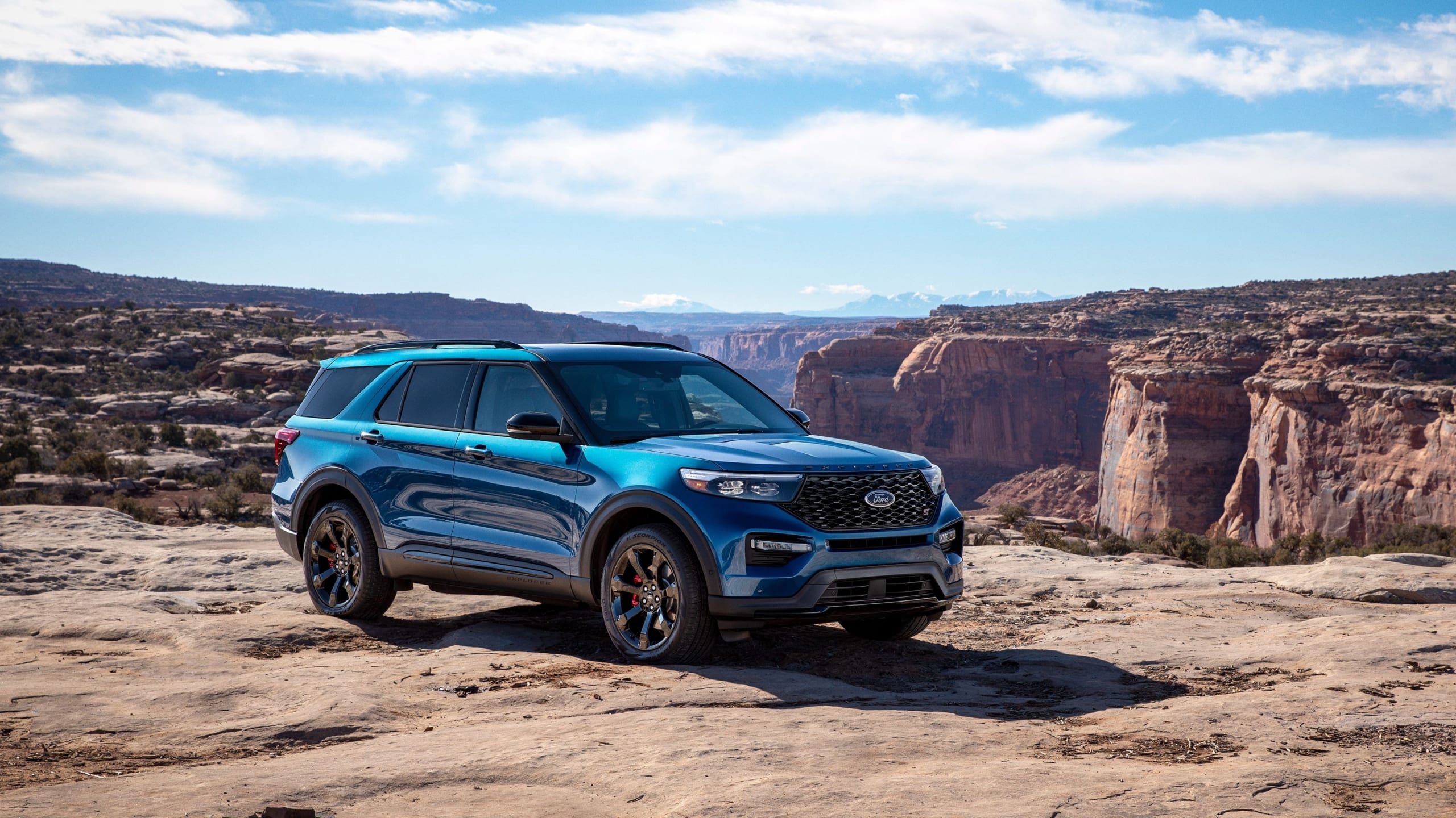 Teal Ford Explorer parked overlooking a gorge with second row and third row seating.