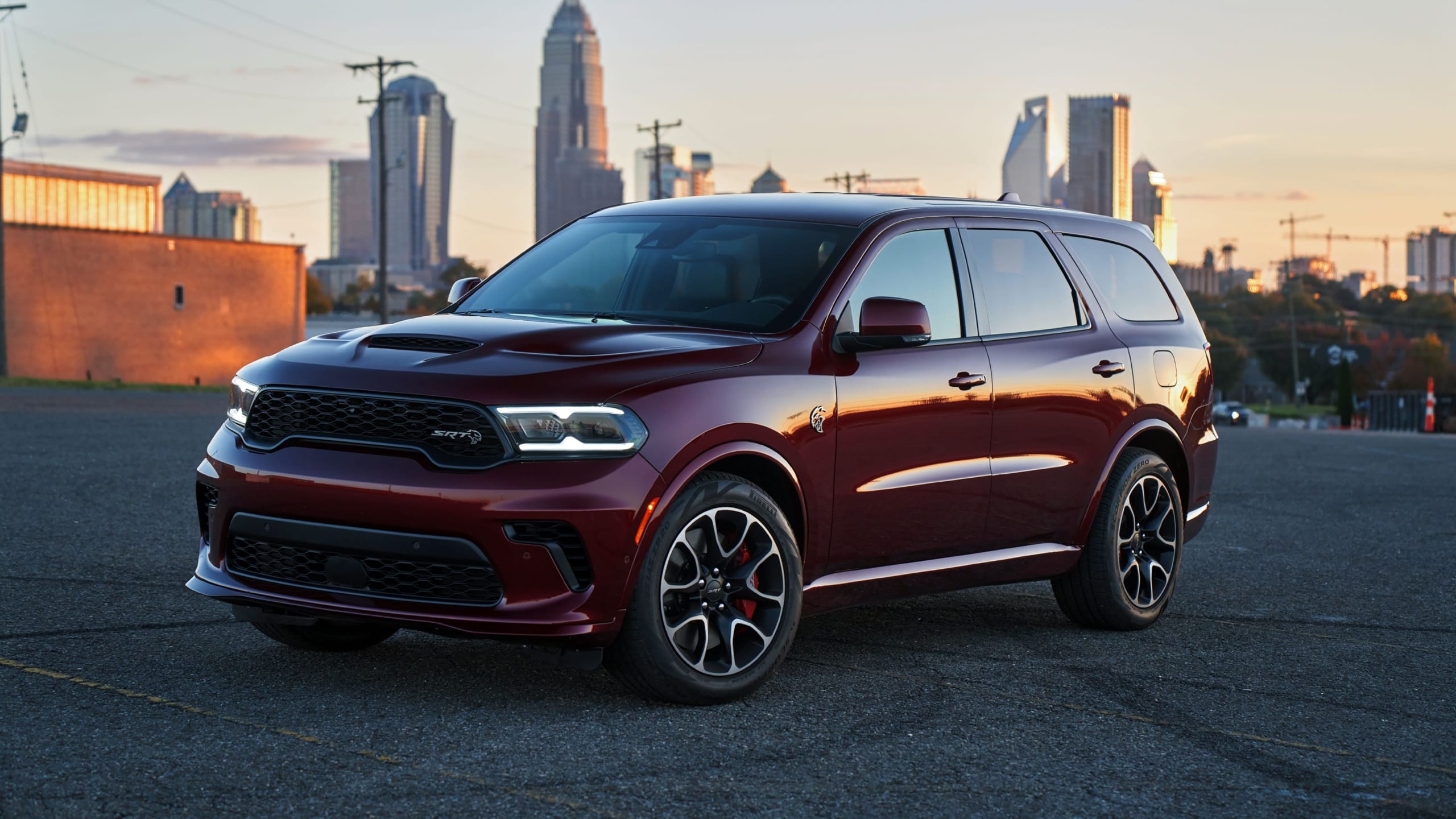 Red Dodge Durango parked on a roof, with a city in the background.