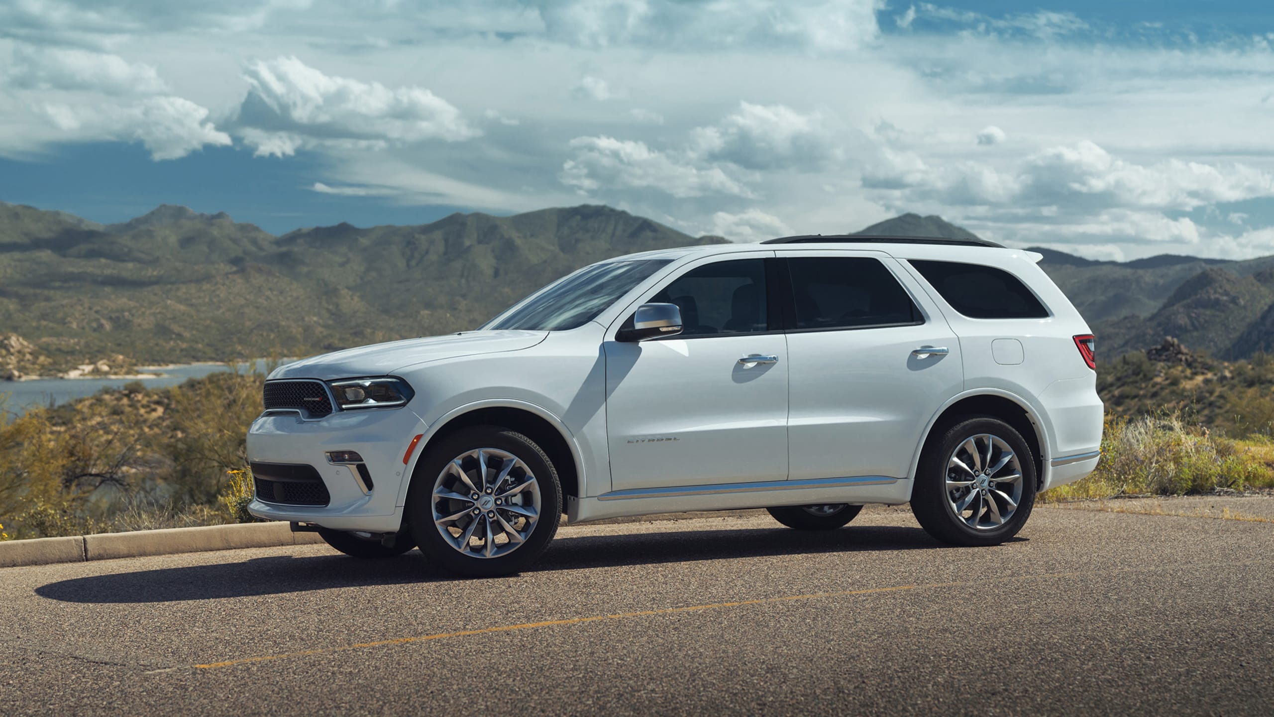 2020 Dodge Durango with high owner satisfaction, parked in the mountains in front of a lake.