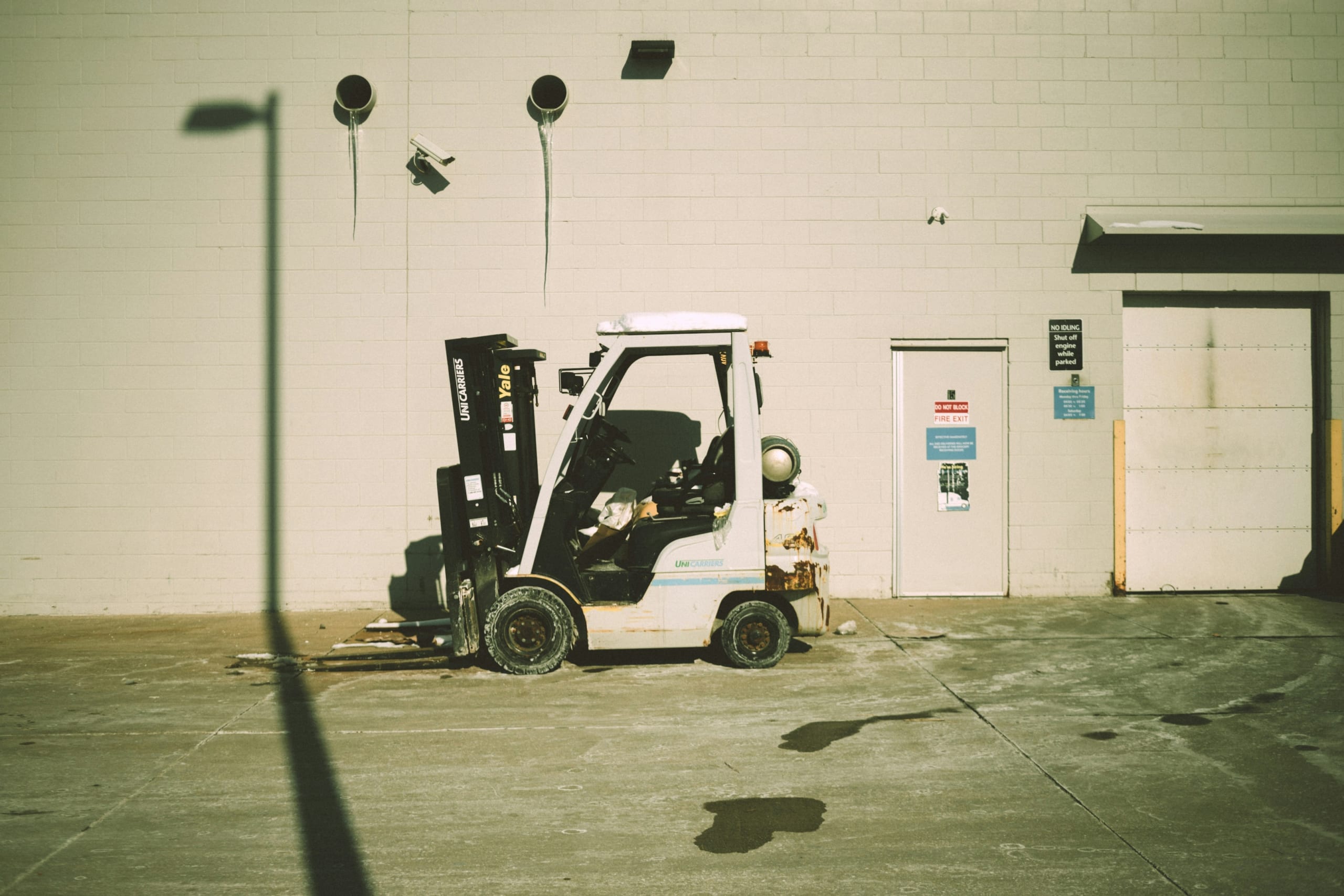 White rough terrain forklift, a good example of material handling equipment, construction equipment, and heavy equipment with an internal combustion engine.