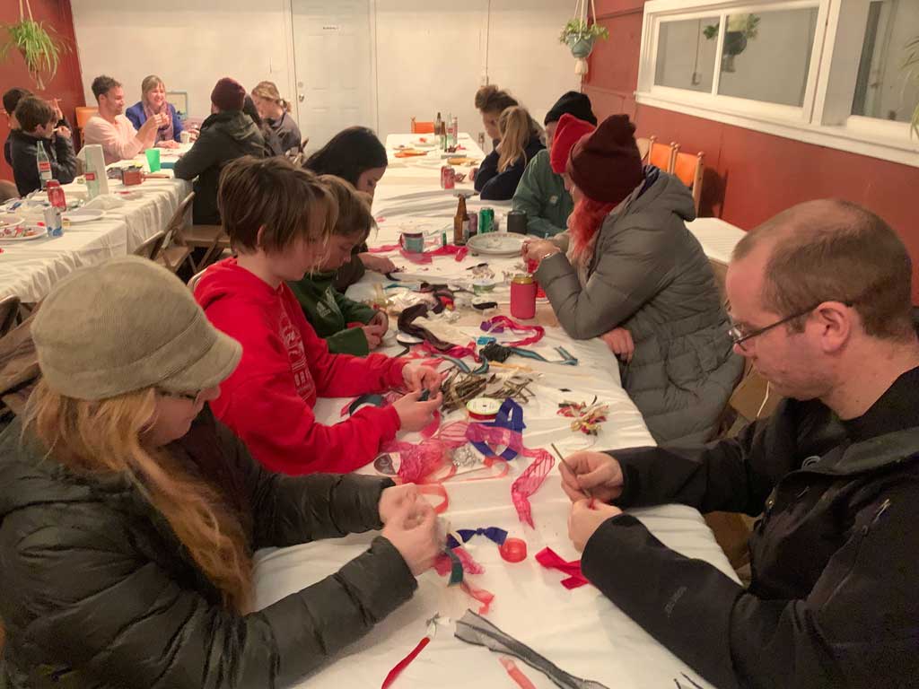 Group crafting Christmas ornaments at a table during a Murmur Creative retreat, with participants engaging in creative activities and sharing a cozy atmosphere.