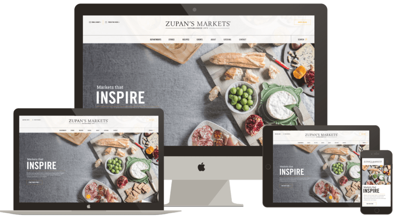 Zupan's Markets website displayed on multiple devices, featuring gourmet food items like cheeses, olives, and charcuterie, with the tagline "Markets that INSPIRE."