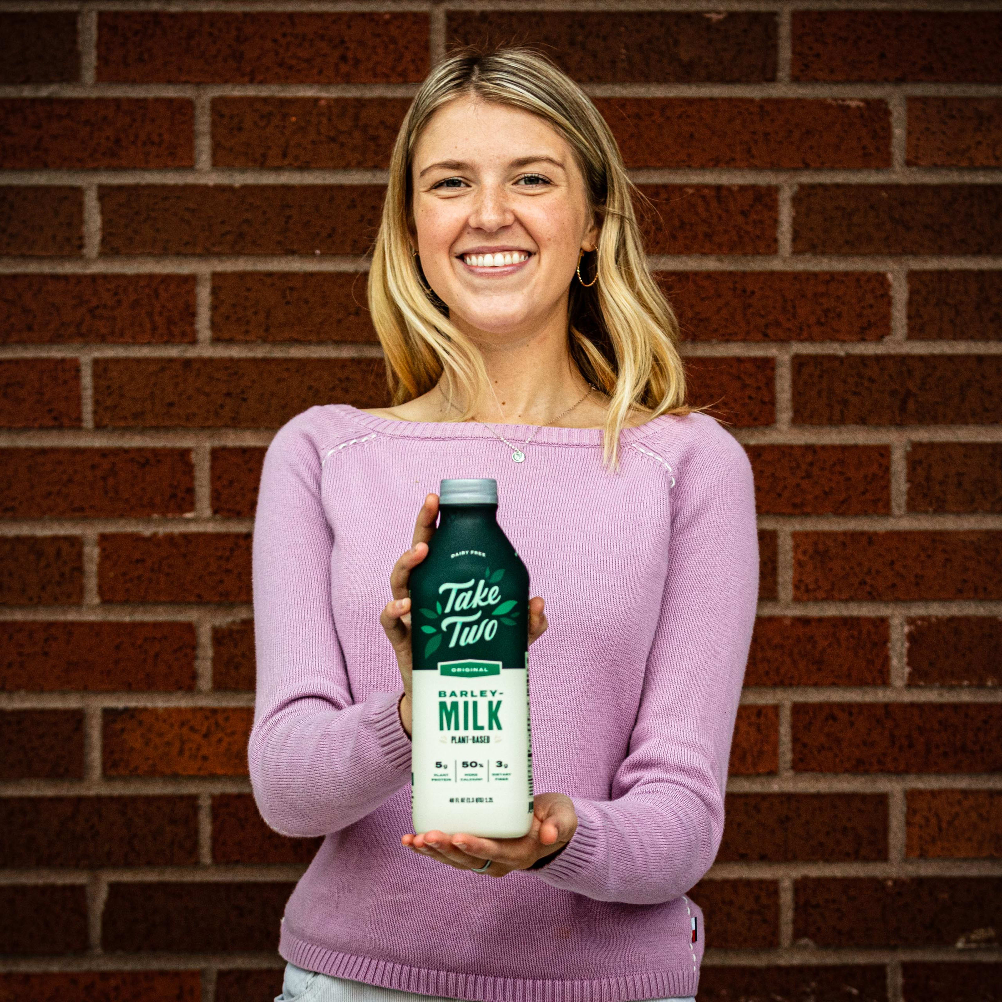 Woman holding Original Take Two bottle