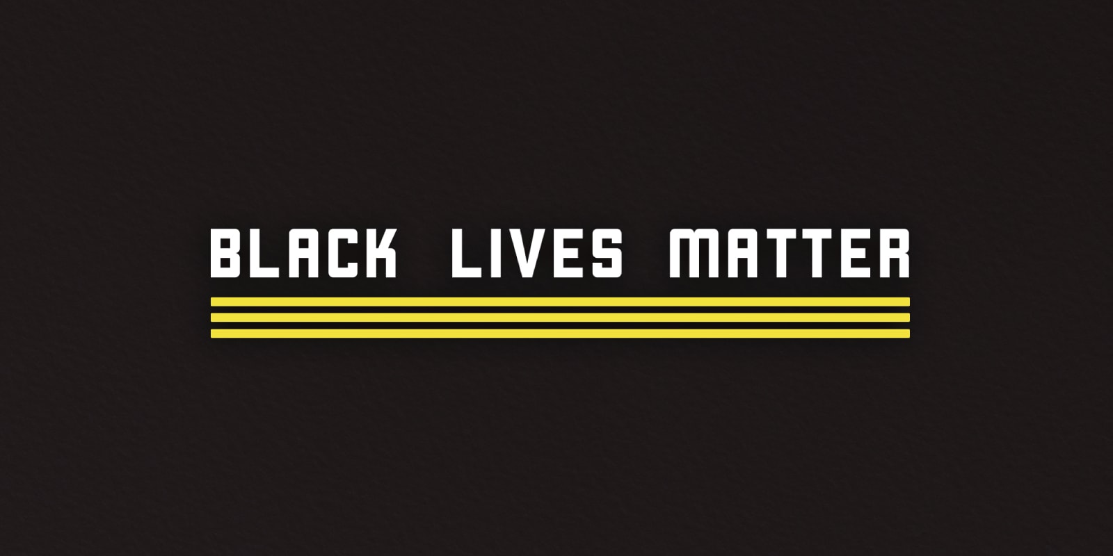 Black Lives Matter text in bold white letters with yellow stripes on a black background, symbolizing solidarity with the Black Lives Matter movement and addressing systemic racism.