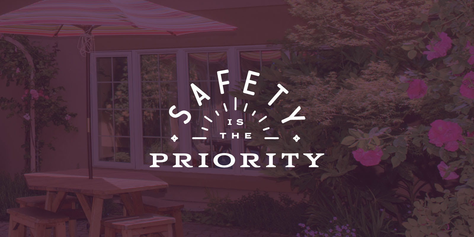 Safety is the Priority graphic overlaying a tranquil outdoor setting with a wooden picnic table, colorful umbrella, and lush greenery, symbolizing support for survivors of domestic violence during the COVID-19 pandemic.