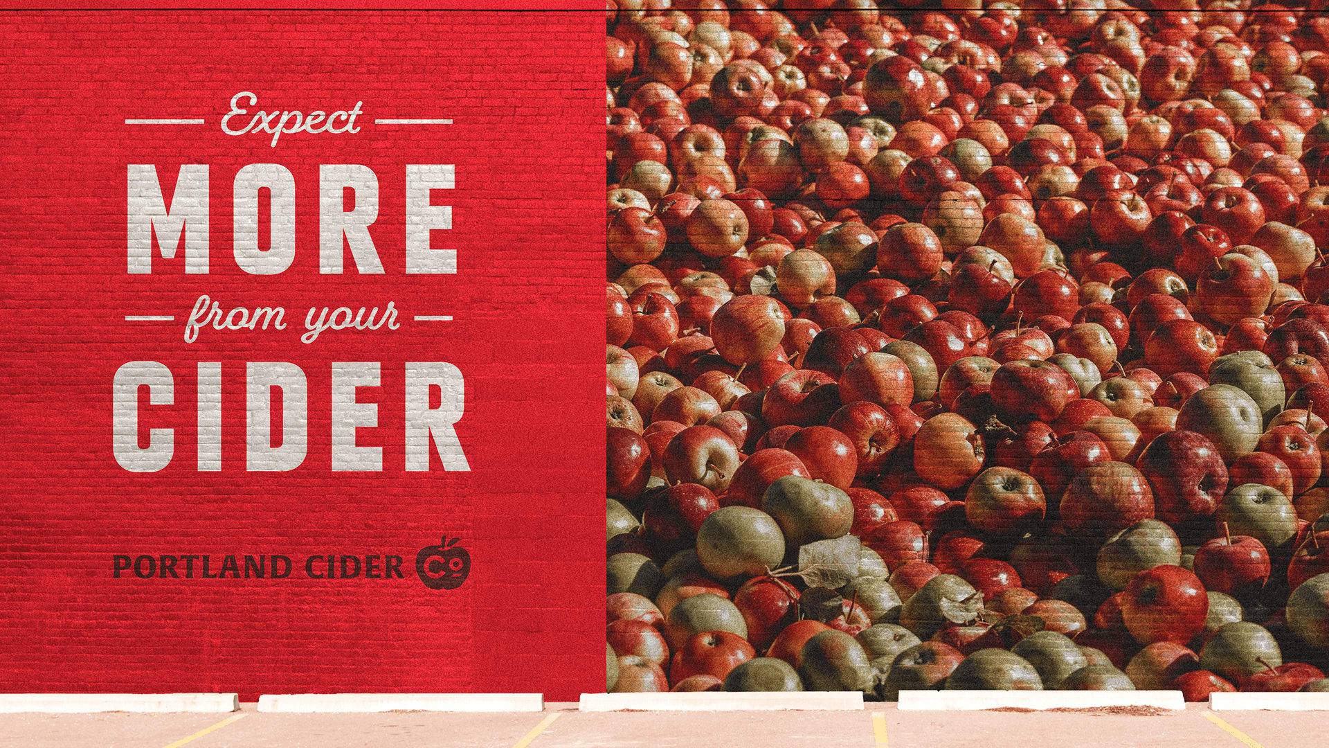 Expect more from your cider mural featuring a vibrant red background and a large assortment of apples, representing Portland Cider Company's new visual identity and commitment to quality craft cider.