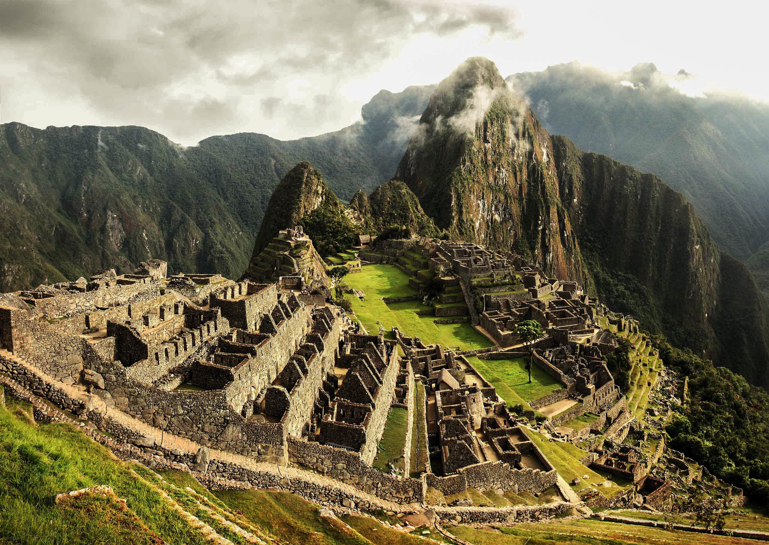 Machu Picchu ruins nestled in lush mountains, showcasing ancient stone structures and greenery, representing adventure travel and exploration for Embark Exploration Co.