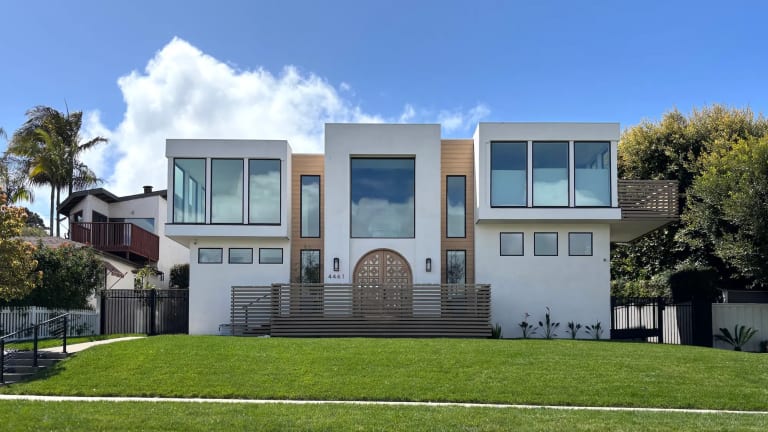 Modern two-story San Diego home with a wood front door and wide lawn