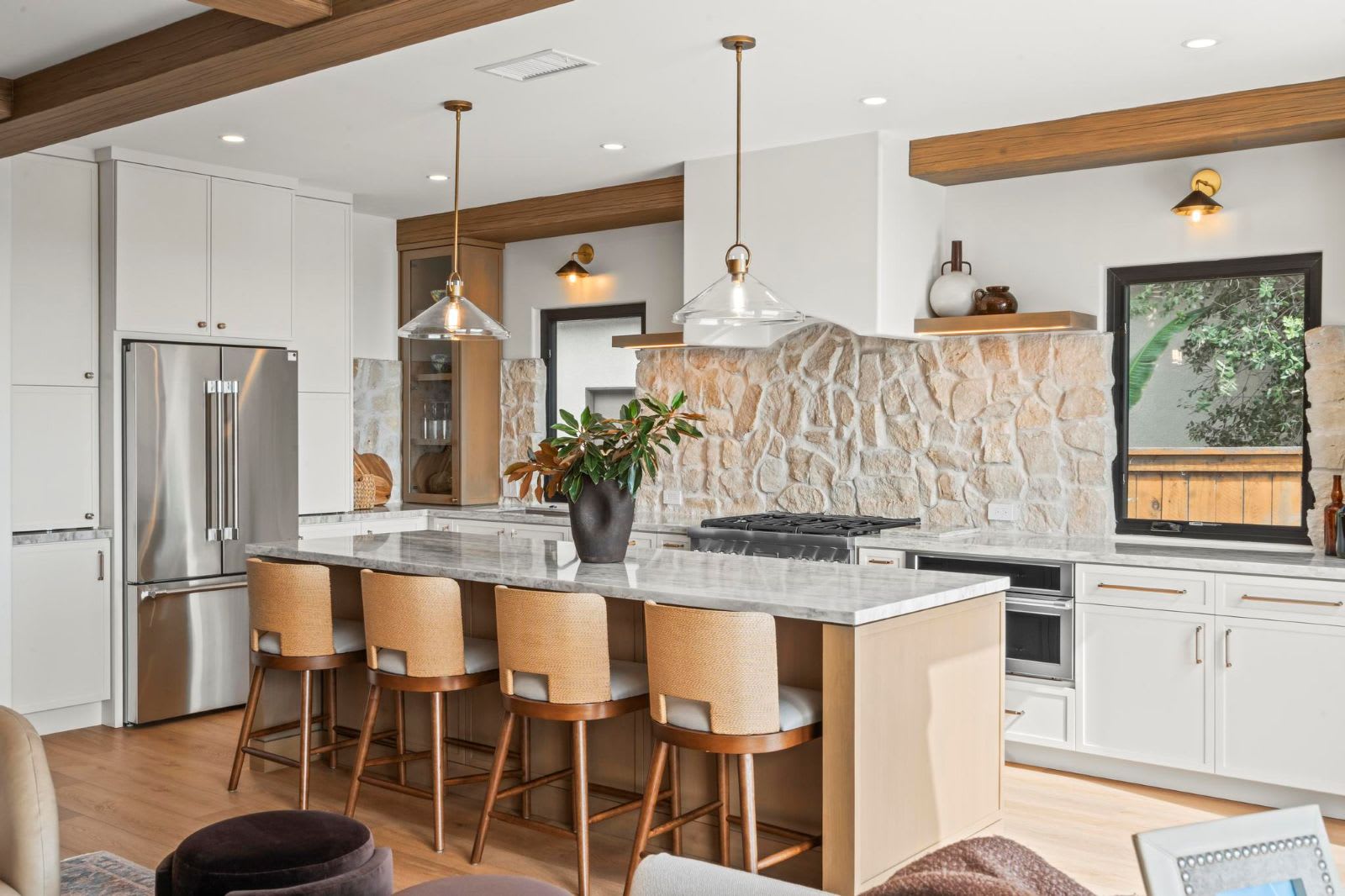 Murray Lampert kitchen remodel with a natural stone backsplash, stone countertops, wood ceiling beams, and a wood-paneled island with seating for four