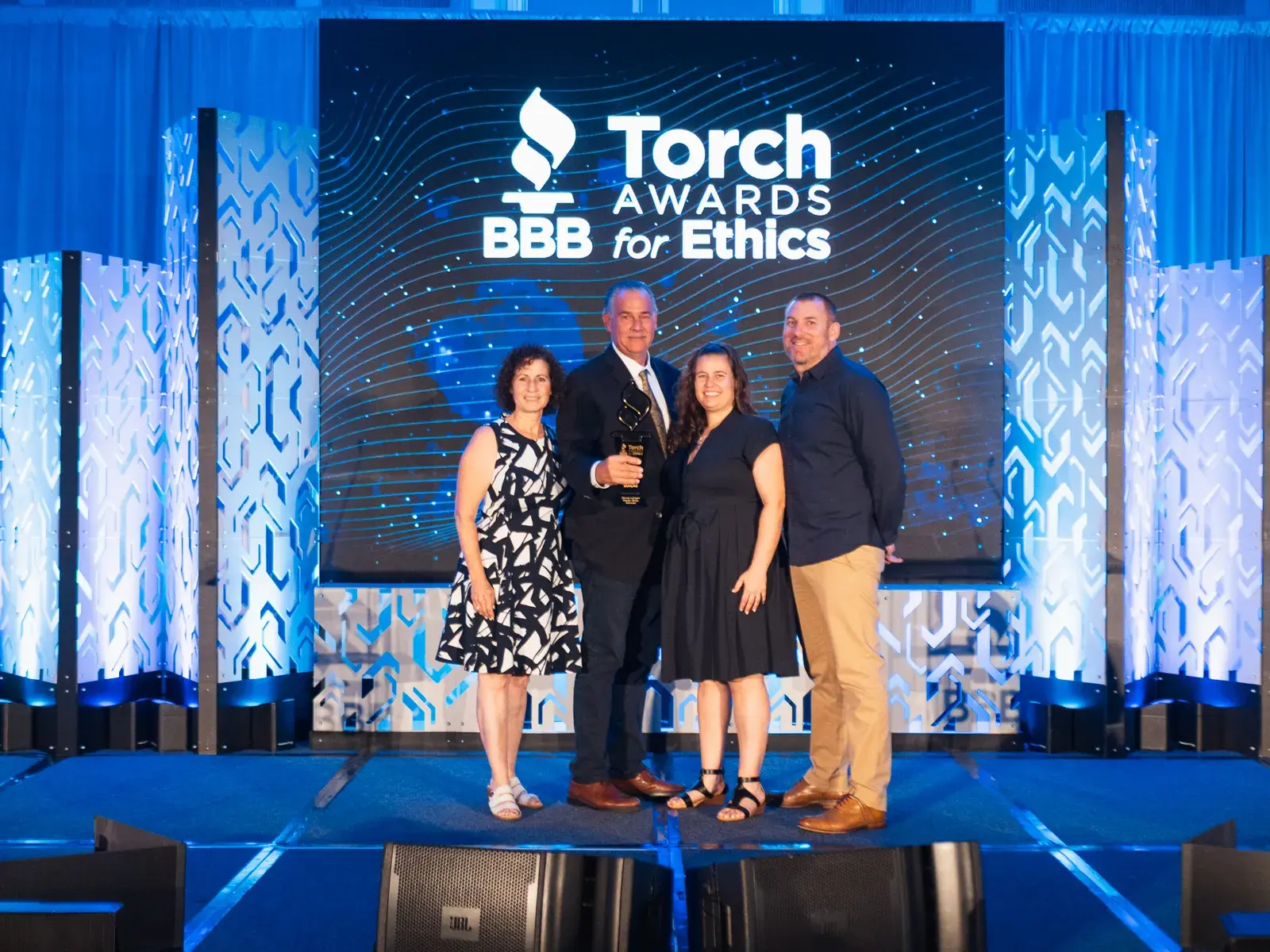 The Murray Lampert team holding the 2026 BBB Torch Award for Ethics on stage at the Torch Awards in La Jolla