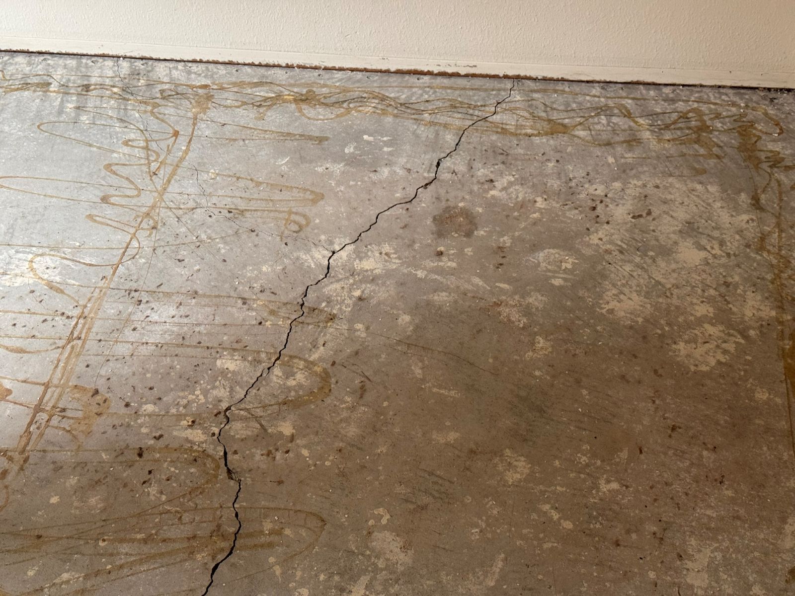 Severely cracked concrete slab revealed after flooring removal - hidden structural defect in a San Diego flipped home