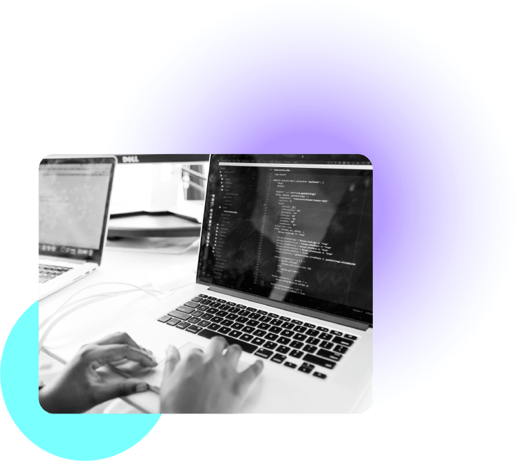 Image of hands typing on a laptop with source code on the screen