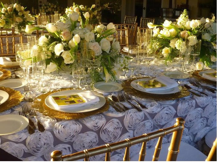 Grand corporate banquet setup in an event hall with long tables, dark linens, high floral centerpieces, and a ceiling draped with string lights. Highlights MICE event furniture rentals and sophisticated Cancun event design for large-scale conference galas and corporate dinners.