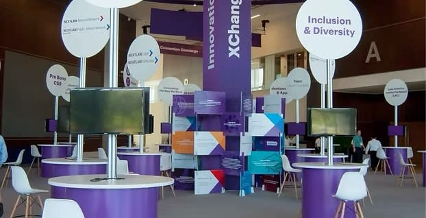 A professional modular exhibition stand at a trade show, with a mix of industrial-themed images, gas meters, and modern digital screens. Illustrates complex stand construction and technical exhibition services for industrial MICE events and conventions.