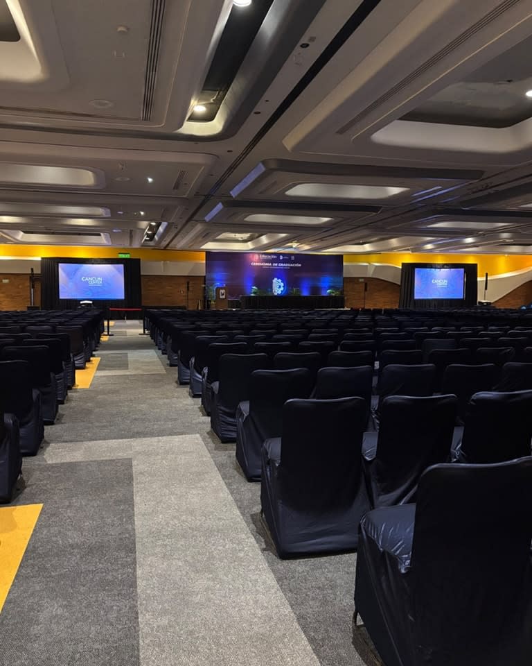 Wide, modern, empty ballroom at the Cancun Convention Center featuring high ceilings and a striking gray and yellow geometric carpet design. This large, versatile space is ideal for setting up a trade show, gala dinner, or large-scale conference for the MICE industry