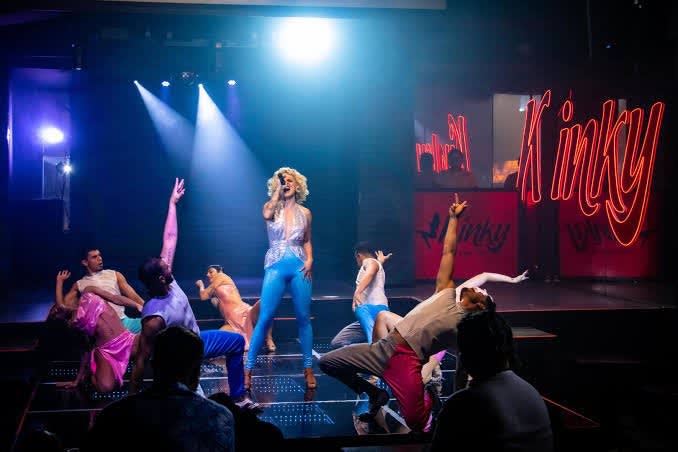 Live stage performance at Grand Oasis Cancun featuring vibrant dancers and a central singer under dramatic lighting—ideal MICE entertainment for incentive groups and corporate events.