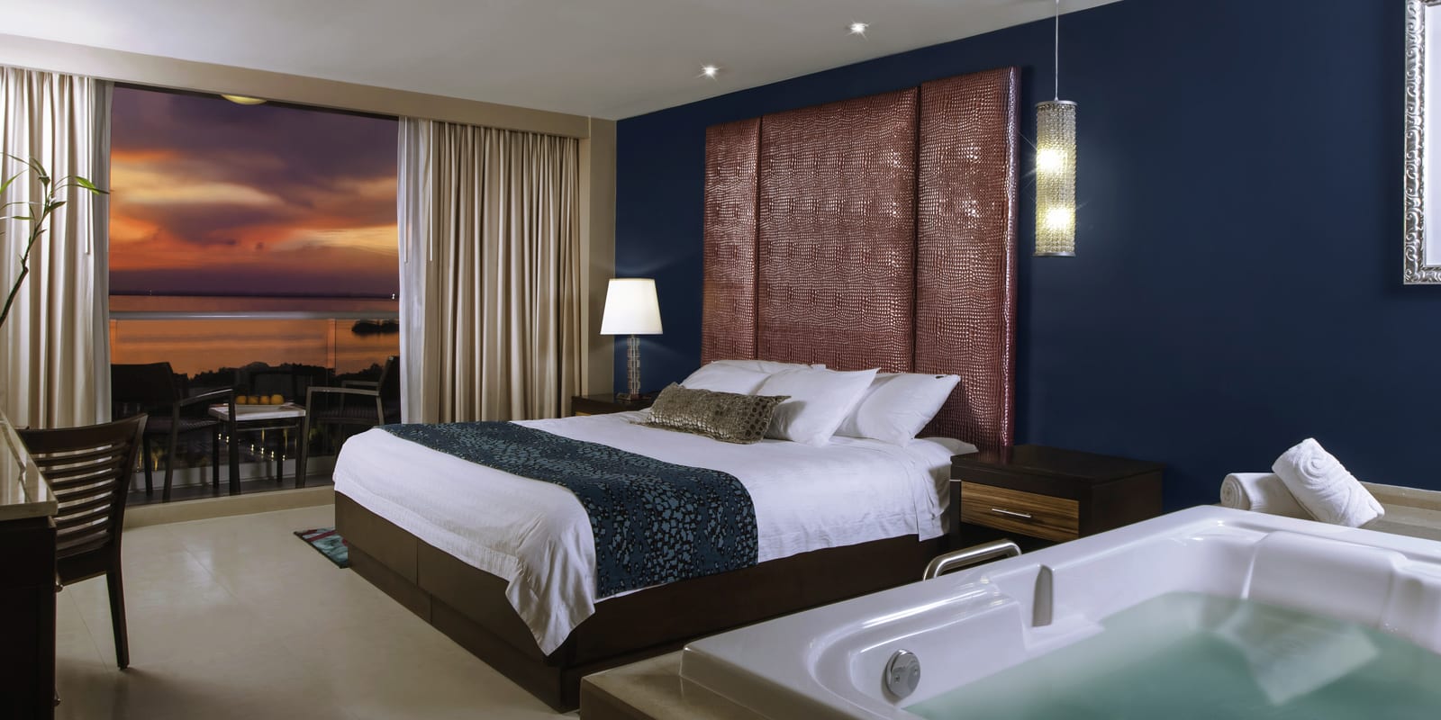 A Deluxe Gold room at Hard Rock Hotel Cancun featuring a king bed and rock-and-roll themed luxury decor. High-end lodging suitable for MICE conference delegates, offering all-inclusive business travel amenities and dedicated workspaces.