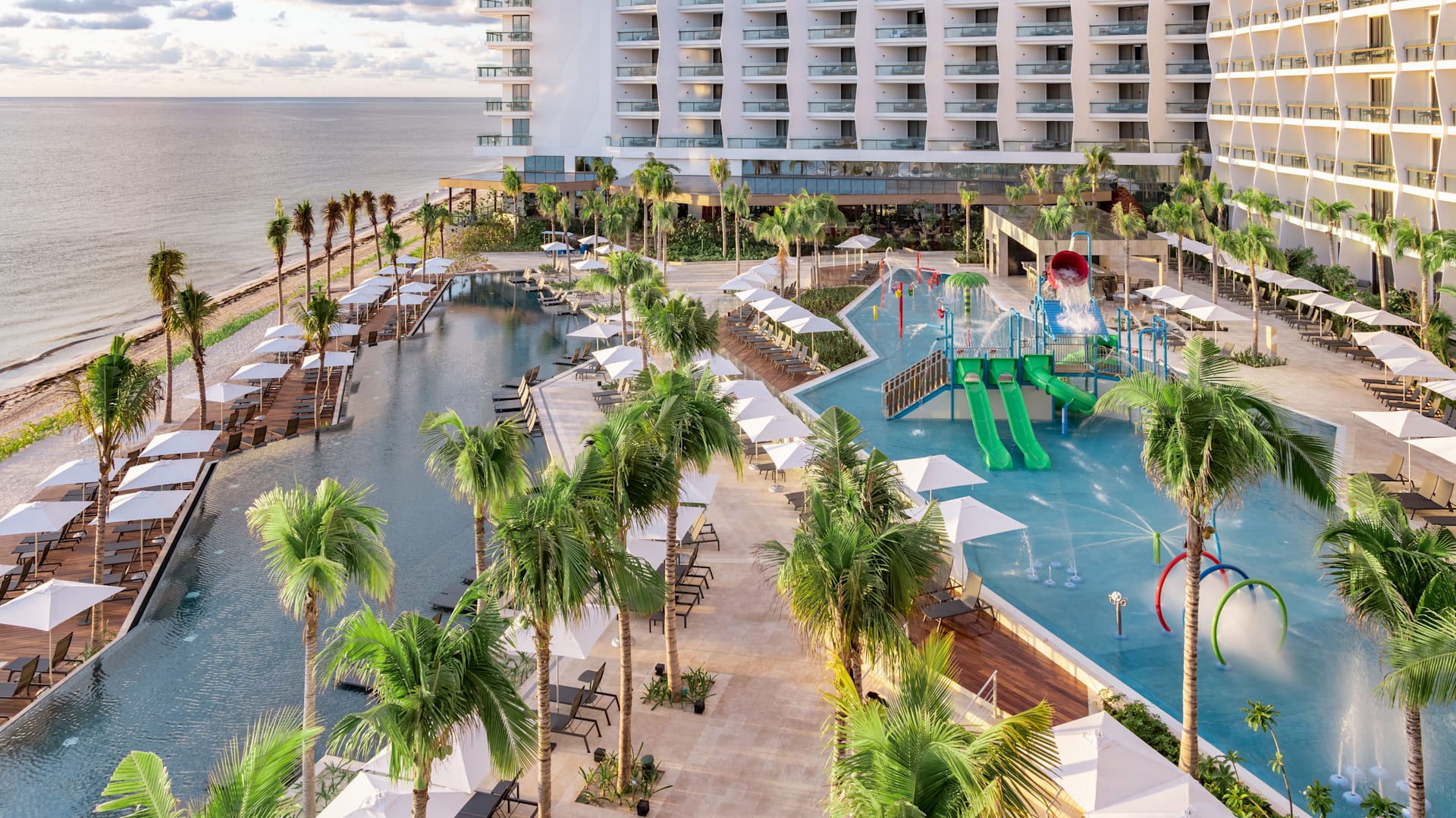 Aerial view of the Hilton Cancun, an All-Inclusive Resort, featuring expansive infinity pools and a splash park. This versatile venue is perfect for MICE groups, incentive travel programs, and corporate retreats that require family-friendly amenities and outdoor networking spaces in Cancun, Mexico.