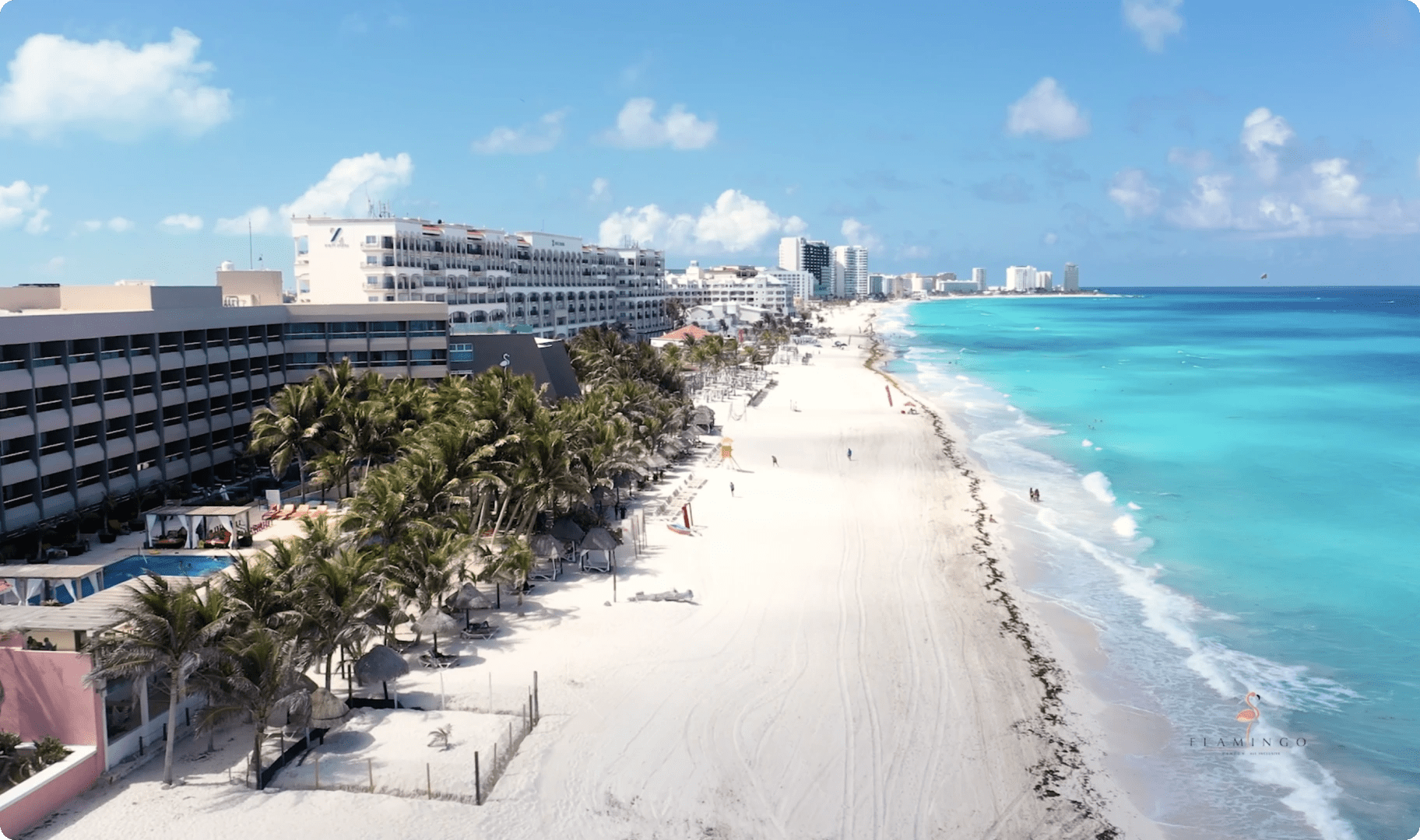  Vibrant daytime aerial view of Hotel Flamingo Cancun All Inclusive, featuring the swimming pool area, white sand beach, and turquoise ocean. A preferred location for MICE planners organizing coastal corporate events, team-building retreats, and tropical incentive travel in Mexico.