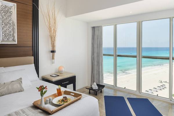 Interior of a luxury king bedroom at Le Blanc Spa Resort Cancun featuring an ocean view, minimalist decor, and high-end amenities, ideal for VIP executive accommodations and incentive travel winners in Mexico.