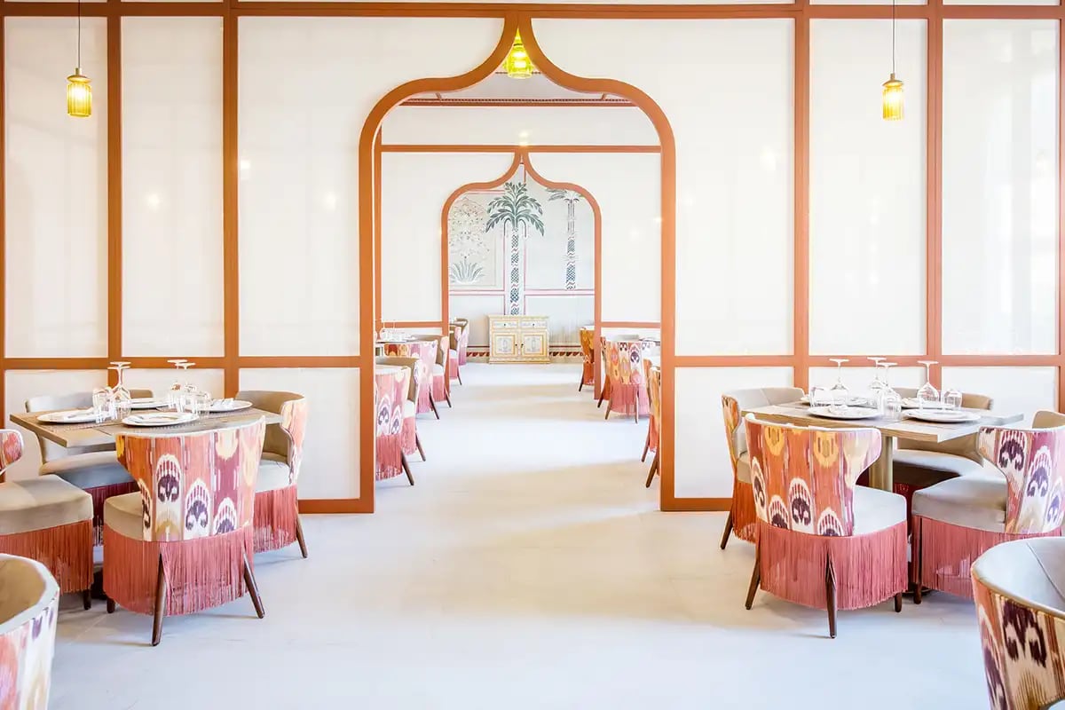Interior of a sophisticated luxury restaurant at Majestic Mirage Costa Mujeres featuring patterned seating, arched entryways, and warm lighting, ideal for high-end MICE group dinners, executive networking events, and incentive travel culinary experiences.