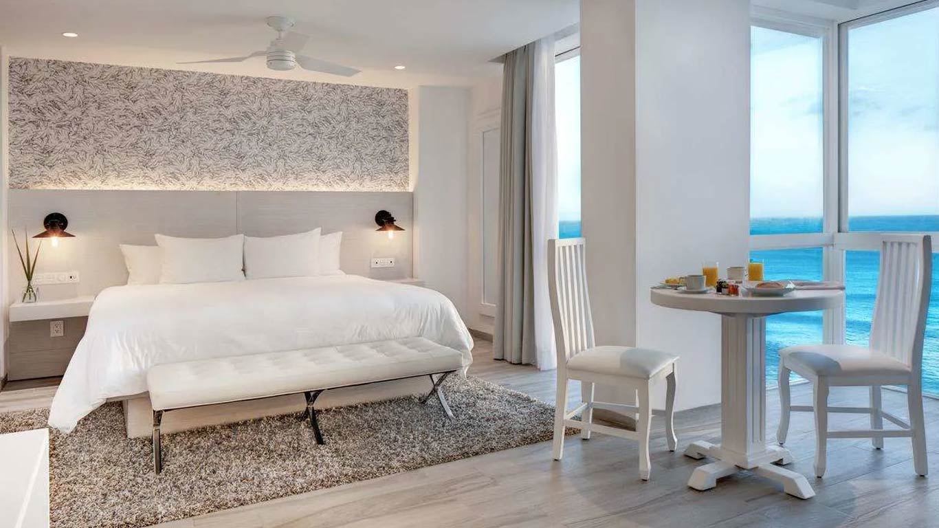 A scenic view of the hacienda-style Mía Cancún Resort featuring its beachfront swimming pool with water fountains and sun terraces, providing a charming and intimate setting for corporate incentive groups and outdoor networking events in the Cancún Hotel Zone.