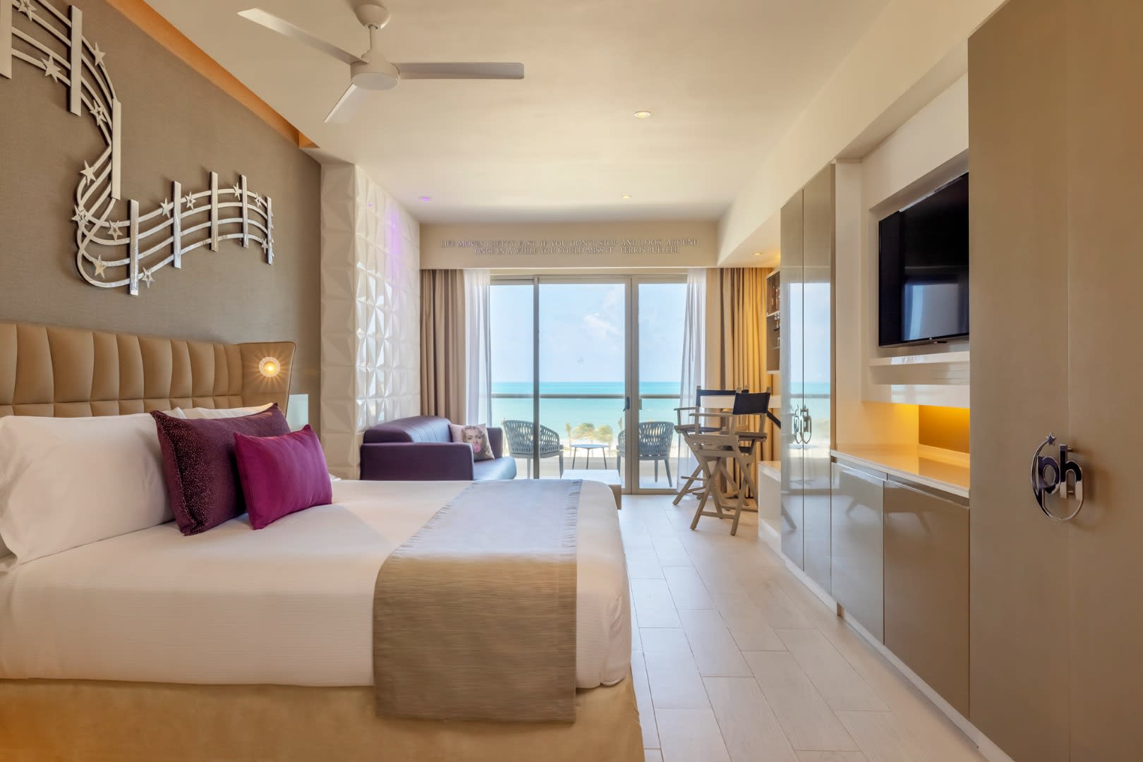 Modern luxury guest room at Planet Hollywood Cancun, An Autograph Collection All-Inclusive Resort, featuring a private balcony with ocean views. This upscale accommodation is designed for MICE industry travelers, offering a blend of comfort and style for corporate delegates and incentive trip winners in Cancun.