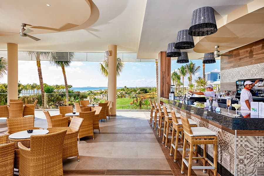 Contemporary executive suite at Riu Palace Costa Mujeres with a king-size bed, integrated lounge area, and modern work desk, providing premium luxury accommodations for incentive travel programs and corporate event attendees.