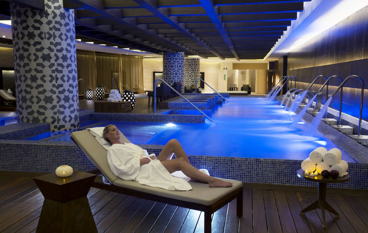 Luxurious indoor spa at Royalton Riviera Cancun featuring hydrotherapy pool, lounge chairs, and tranquil ambiance—ideal for MICE guests seeking wellness during corporate retreats or incentive travel.