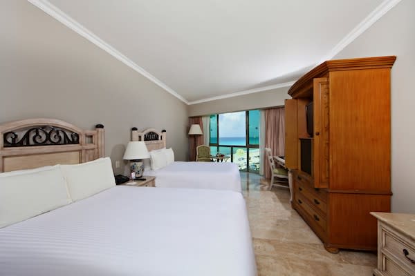 Oceanview double room at Sandos Cancun featuring two beds, balcony seating, and executive-friendly amenities—ideal for MICE guests attending meetings, incentives, or corporate retreats in Mexico.