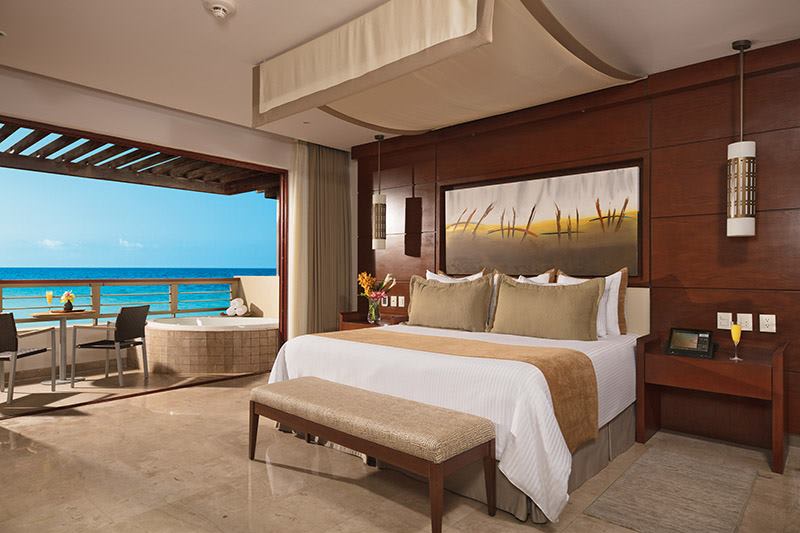 Oceanview suite at Secrets Playa Mujeres Golf & Spa Resort featuring elegant decor, private balcony, in-room hot tub, and executive amenities—ideal for MICE travelers attending incentive programs, corporate retreats, or high-level meetings in Mexico.