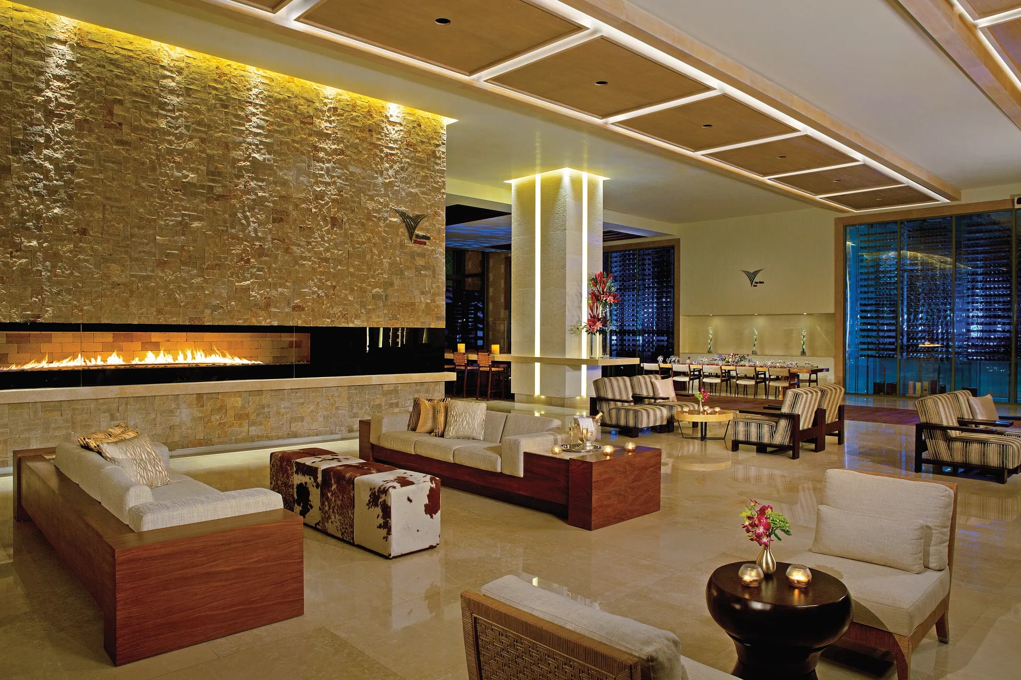 Elegant lobby lounge at Secrets The Vine Cancun featuring ambient lighting, plush seating, and wine display—ideal for MICE guests seeking stylish networking spaces, executive comfort, and upscale hospitality in Mexico.