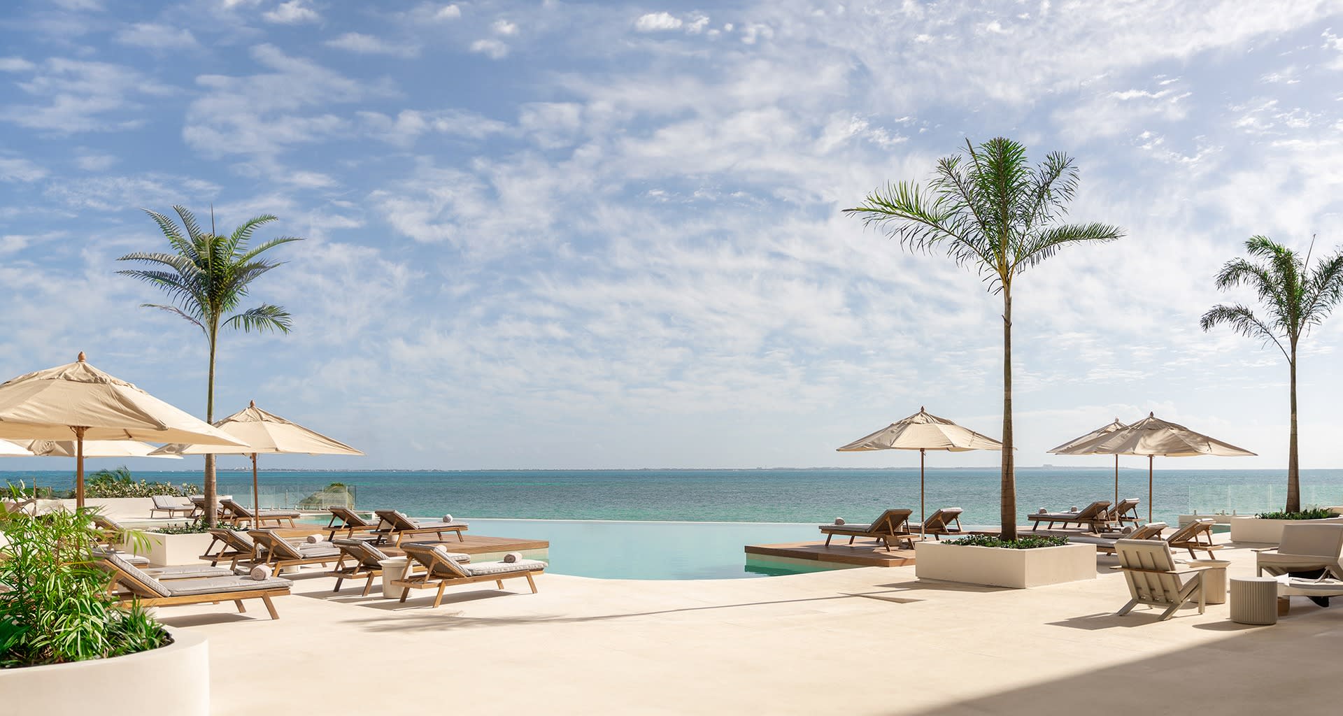 Beachfront infinity pool at SHA Wellness Clinic Mexico with cushioned lounge chairs, tropical landscaping, and ocean horizon—ideal for MICE wellness retreats, incentive travel, and executive recharge programs in Mexico.