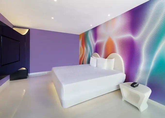 Contemporary guestroom at Temptation Cancun Resort featuring a vibrant abstract mural, minimalist furnishings, and artistic lighting—ideal for MICE VIP stays, incentive travel, and creative corporate retreats in Mexico.