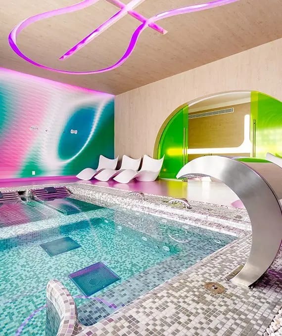 Colorful indoor spa lounge at Temptation Cancun Resort featuring mosaic-tiled pool, sculptural loungers, and ambient lighting—ideal for MICE wellness breaks, incentive travel, and executive relaxation experiences in Mexico.