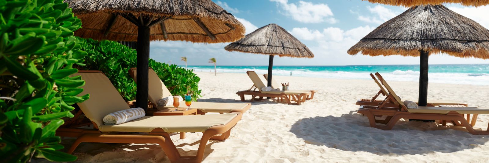 Beachfront relaxation area at The Westin Lagunamar with luxury lounge chairs, thatched palapas, and tropical cocktails on white sand. A prime location for MICE industry networking events, corporate beach parties, and outdoor team-building activities in Mexico.
