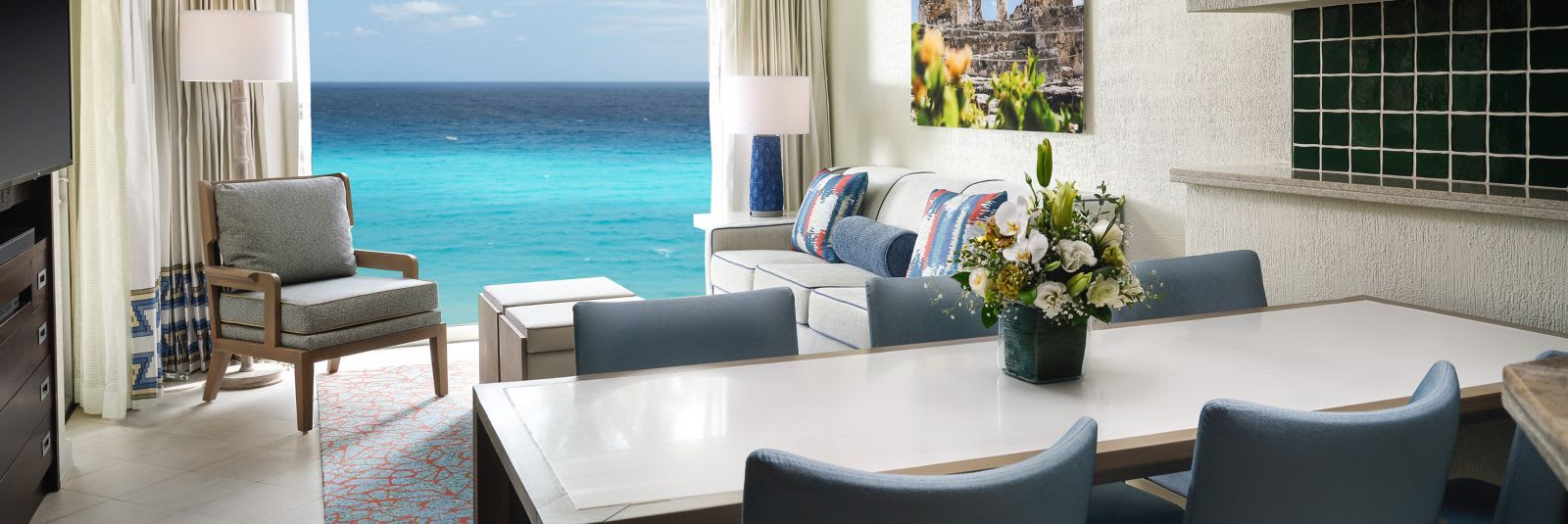 Interior view of a luxury ocean-front villa at The Westin Lagunamar, featuring a spacious living area, dining table, and floor-to-ceiling windows overlooking the Caribbean Sea. Ideal for executive incentive travel and high-level corporate delegates, providing a sophisticated environment for small private meetings or luxury group stays.