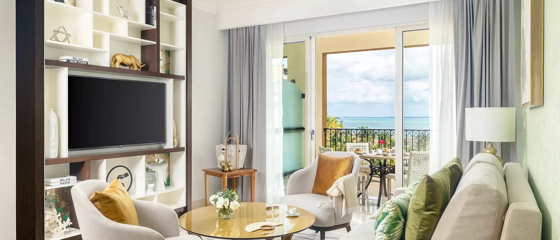 Modern luxury suite interior at Villa del Palmar Cancun, featuring a sophisticated living area with a large flat-screen TV, elegant decor, and a private balcony overlooking the Caribbean Sea. This upscale accommodation is perfect for executive incentive travel, providing a premium sanctuary for high-level delegates and keynote speakers attending MICE events in Mexico.