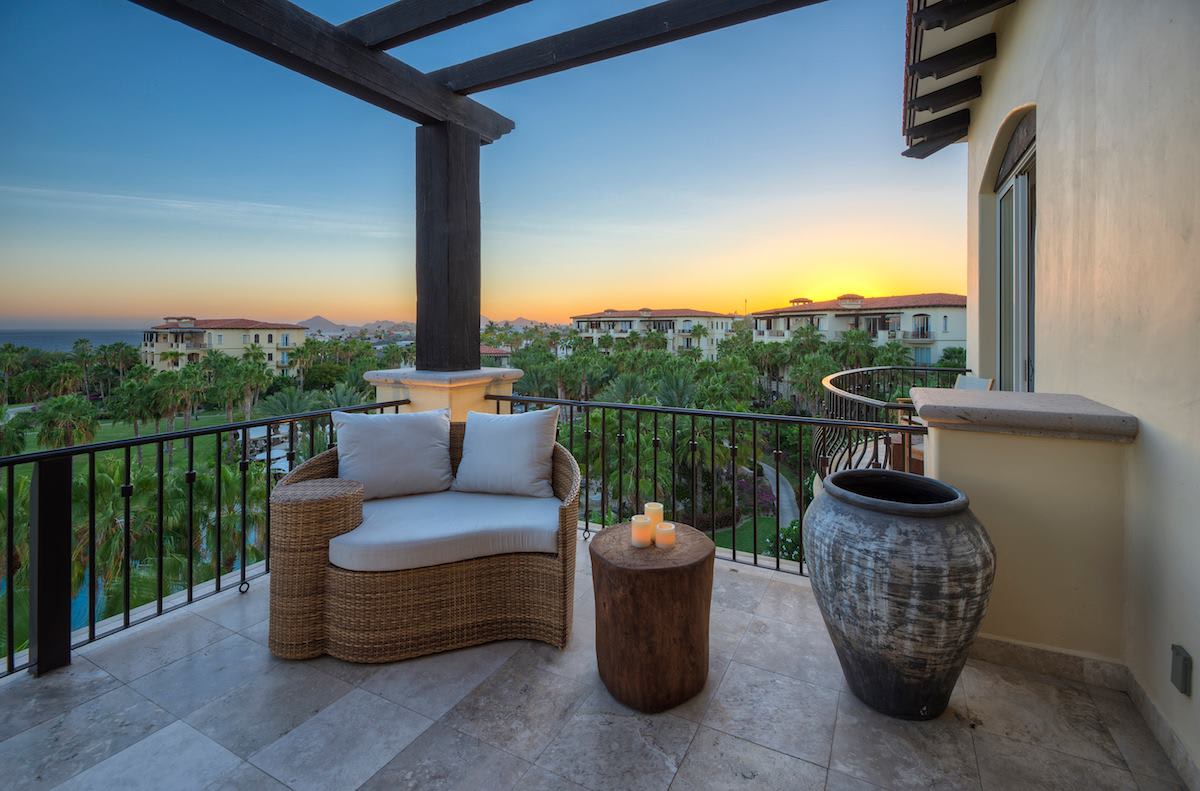 Sunset balcony at Esperanza, Auberge Collection in Cabo San Lucas featuring cushioned seating, candlelit accents, and tropical views—ideal for MICE executive retreats, incentive travel, and private networking moments