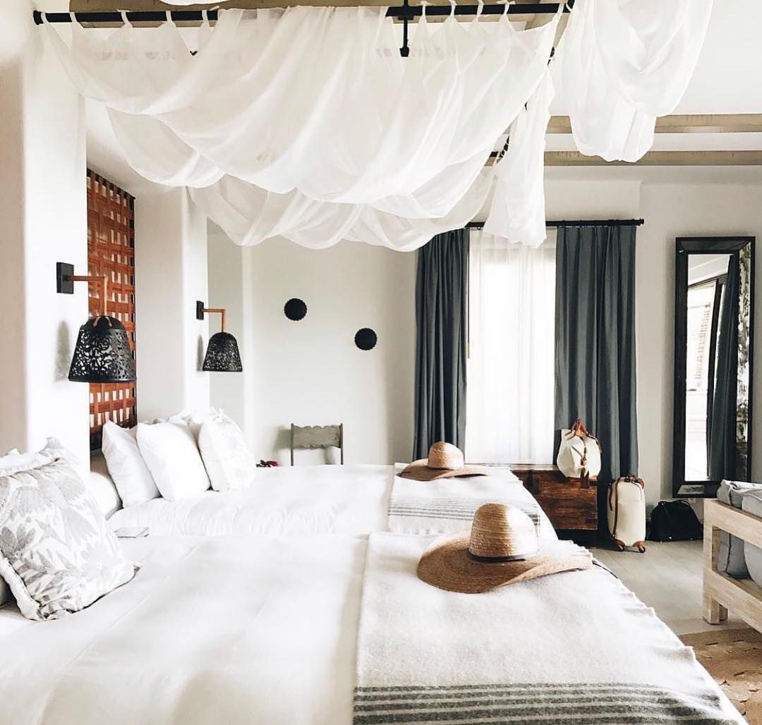 Cozy double-bed suite at Esperanza, Auberge Collection in Cabo San Lucas featuring canopy accents, rustic-modern decor, and natural lighting—ideal for MICE group accommodations, incentive travel, and shared executive stays.