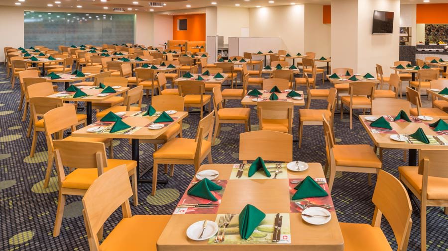 Spacious restaurant at Camino Real Aeropuerto México featuring organized seating for large groups, ideal for MICE event catering, business breakfasts, and corporate dinner functions.