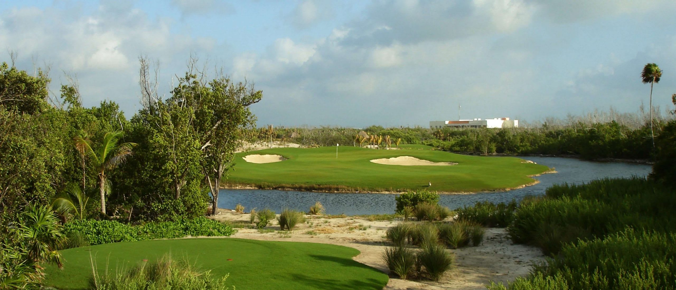 A challenging and beautiful hole at Riviera Cancun Golf Club, featuring an island green surrounded by water and mangroves. This unique environment is ideal for incentive travel groups and adds a memorable element to a corporate golf tournament.