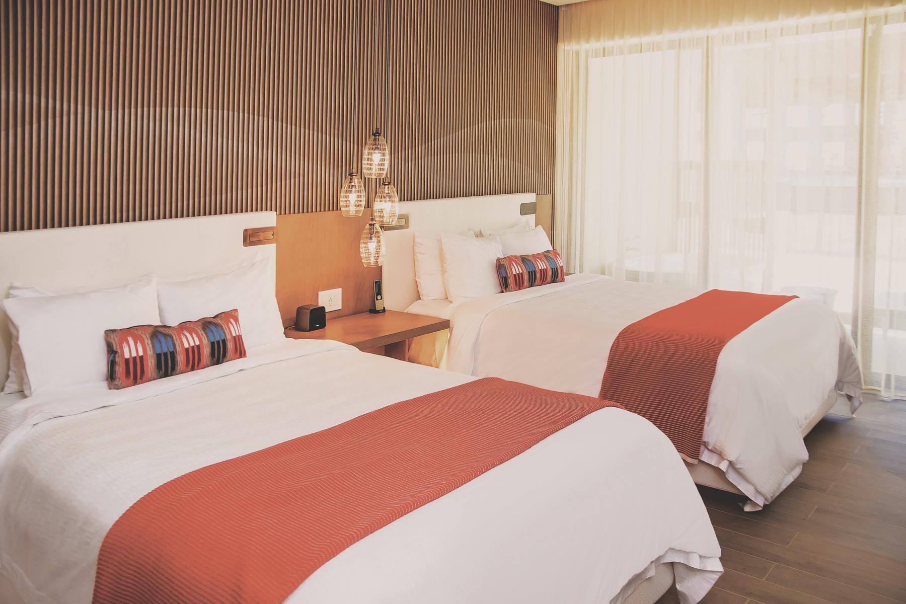Modern double-bed room at Hard Rock Hotel Los Cabos featuring pendant lighting, wood accents, and natural light—ideal for MICE group stays, incentive travel, and shared executive accommodations in Baja California Sur.